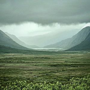 Scenic view of land and mountains against sky