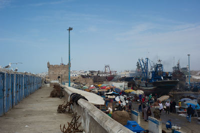 Street by harbor against sky in city