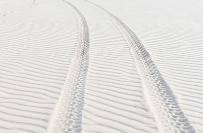 High angle view of tire tracks at sandy desert