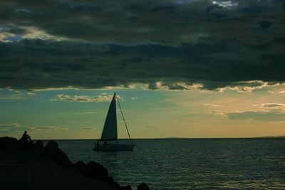 Silhouette sailboat sailing on sea against sky during sunset