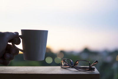 Close-up of hand holding coffee cup