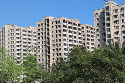 Low angle view of buildings against clear blue sky