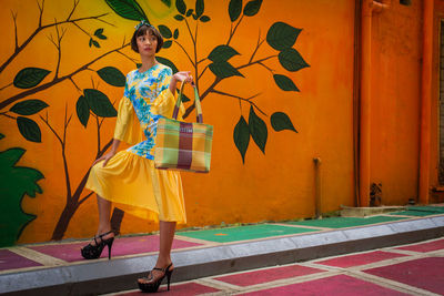 Female model standing against patterned wall