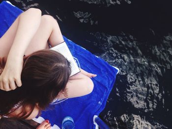 Close-up of girl against blue water