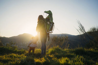 Spain, barcelona, grandmother with granddaughter during a hike at sunset