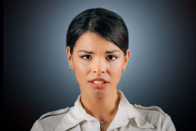 Portrait of woman against black background