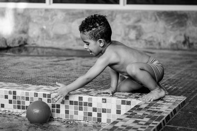 Boy playing with ball at poolside