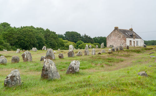 Old ruins on field by building against sky