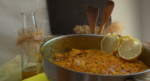 Seafood paella with lemon on kitchen table