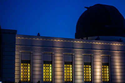 Low angle view of illuminated building against blue sky