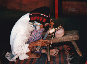 Man sitting on wood at night