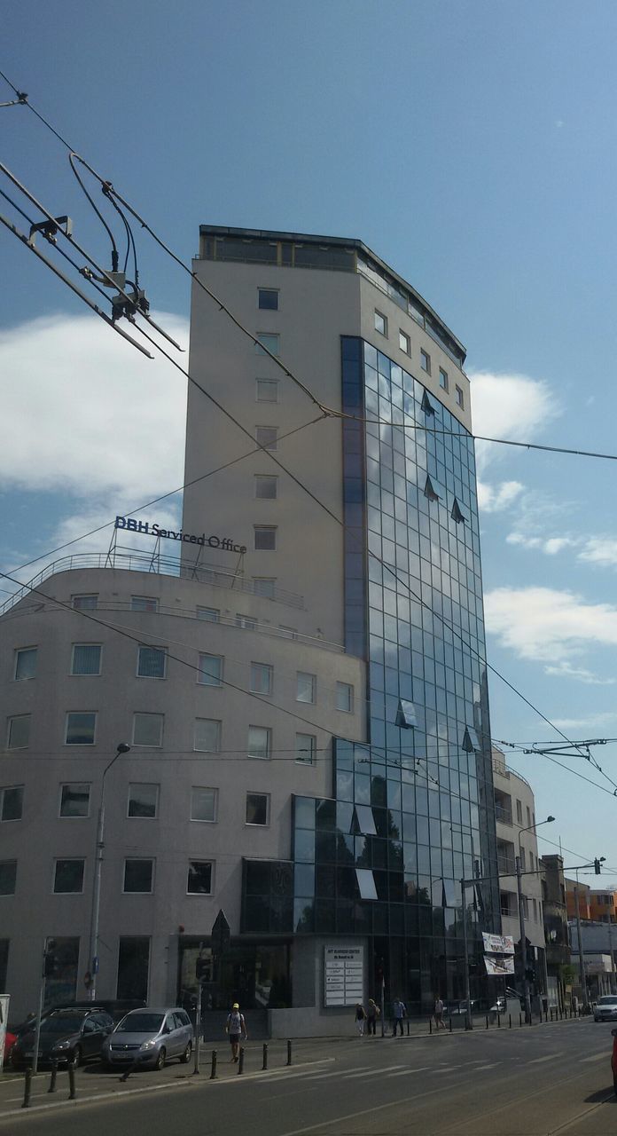 building exterior, architecture, built structure, transportation, land vehicle, car, city, mode of transport, street, sky, low angle view, road, building, power line, city street, city life, cable, street light, electricity pylon, day