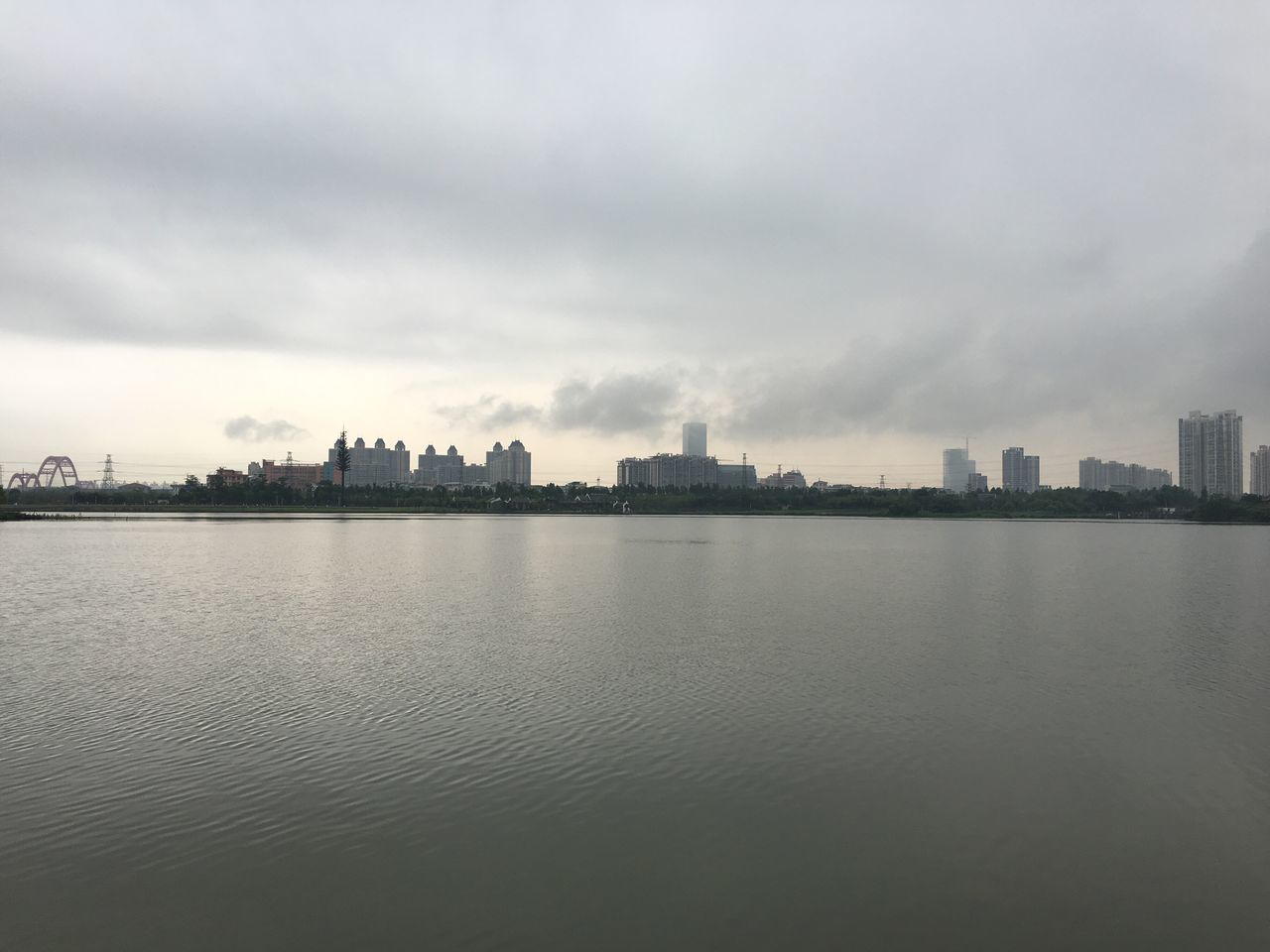 water, sky, building exterior, waterfront, architecture, built structure, city, sea, cloud - sky, cloudy, cloud, river, rippled, cityscape, tranquility, scenics, tranquil scene, nature, dusk, overcast
