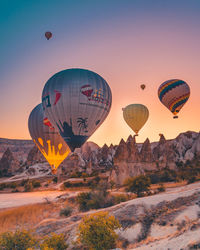 Hot air balloon flying over mountains against sky