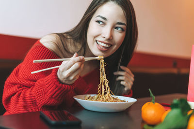 Portrait of a smiling young woman holding food