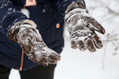 Cropped image of hands showing snow on gloves