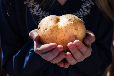 Midsection of woman holding raw potato