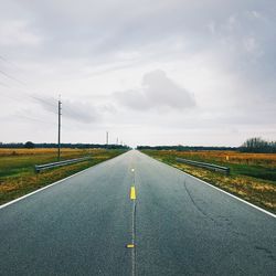 Road by landscape against sky