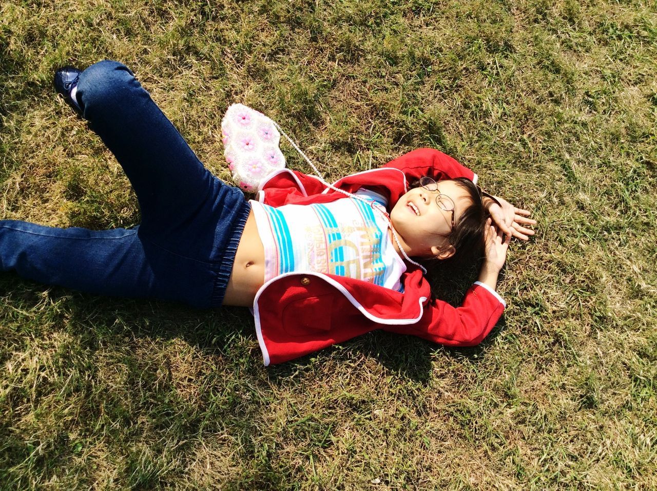 grass, lifestyles, field, relaxation, grassy, leisure activity, casual clothing, sitting, lying down, person, full length, childhood, high angle view, resting, elementary age, low section, shoe, lying on back