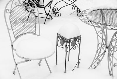 High angle view of empty chairs and table against white background