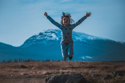 Full length of person jumping against sky