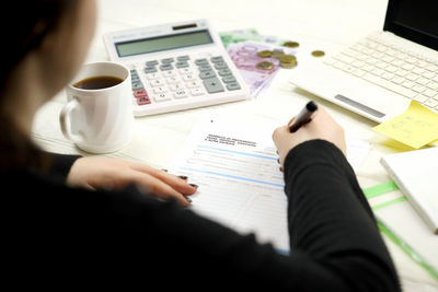 Cropped hand of businessman working on table