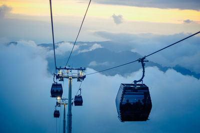 Overhead cable car against clouds in the sky