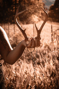 Cropped hand of woman standing against sky