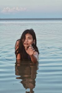 Portrait of woman standing against sea