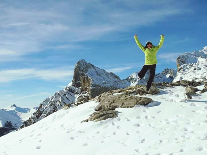 LOW ANGLE VIEW OF PEOPLE STANDING ON SNOW COVERED MOUNTAIN AGAINST BLUE SKY