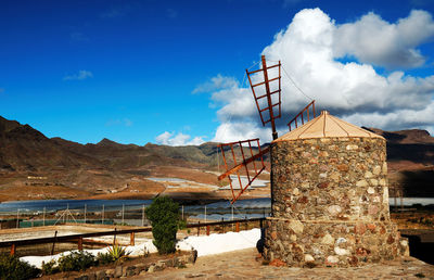 Traditional windmill at pilancones natural park against cloudy sky