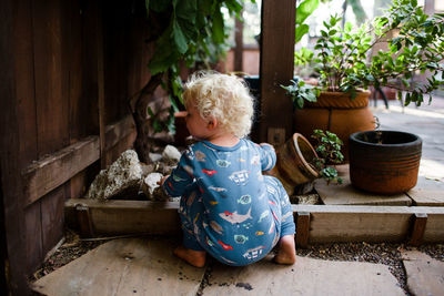 Cute girl sitting on potted plant