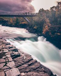 Scenic view of waterfall against sky