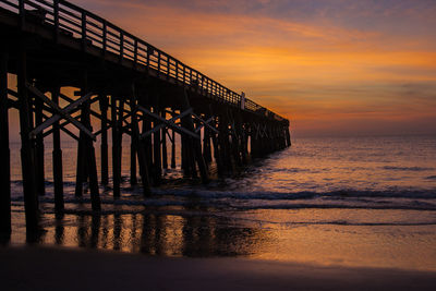 Pier over sea against sky during sunset