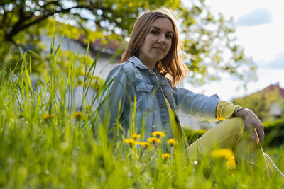 Portrait of young woman sitting on field
