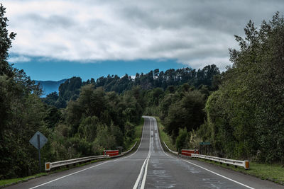 Road amidst trees against sky