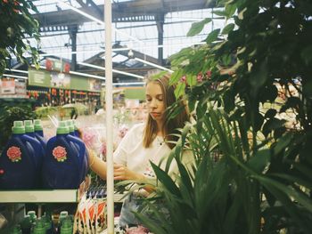 Portrait of woman looking at plants