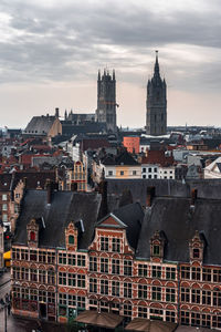 Buildings in city against cloudy sky