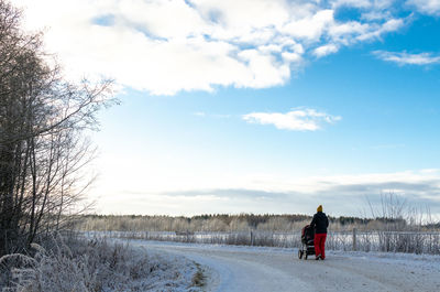 Rear view of person on snow field against sky