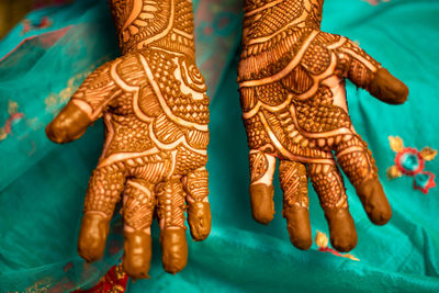 Midsection of bride showing henna tattoo