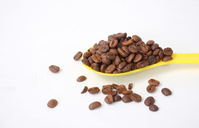 Close-up of roasted coffee beans against white background