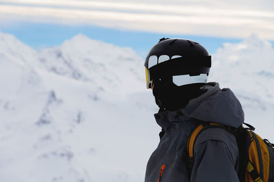 Rear view of man standing on snow covered mountain