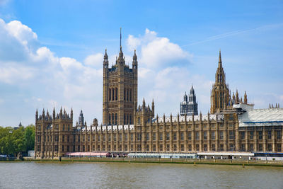 Buildings in city against cloudy sky