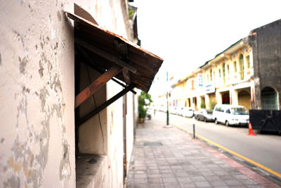 Street and footpath amidst buildings against clear sky