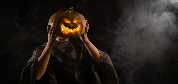 Close-up of illuminated jack o lantern against black background