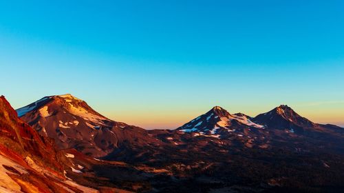 Scenic view of snowcapped mountains against clear blue sky