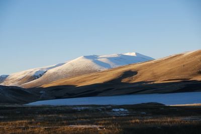 Scenic view of snowcapped mountains against clear blue sky