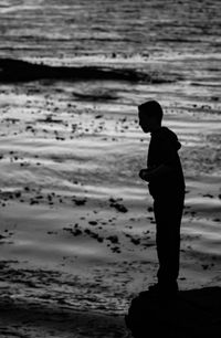 Full length of silhouette boy standing at beach