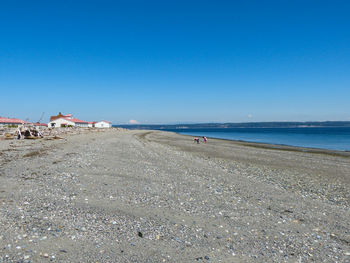 Scenic view of beach against clear blue sky