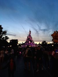 People at temple against sky during sunset